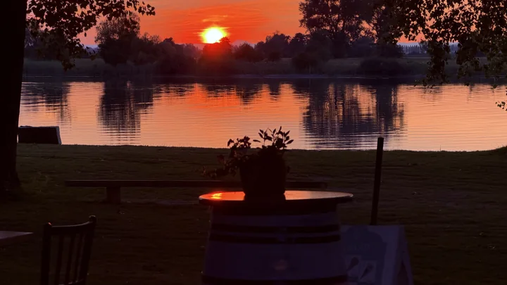 Gedeckter Tisch mit Blick auf den roten Sonnenuntergang